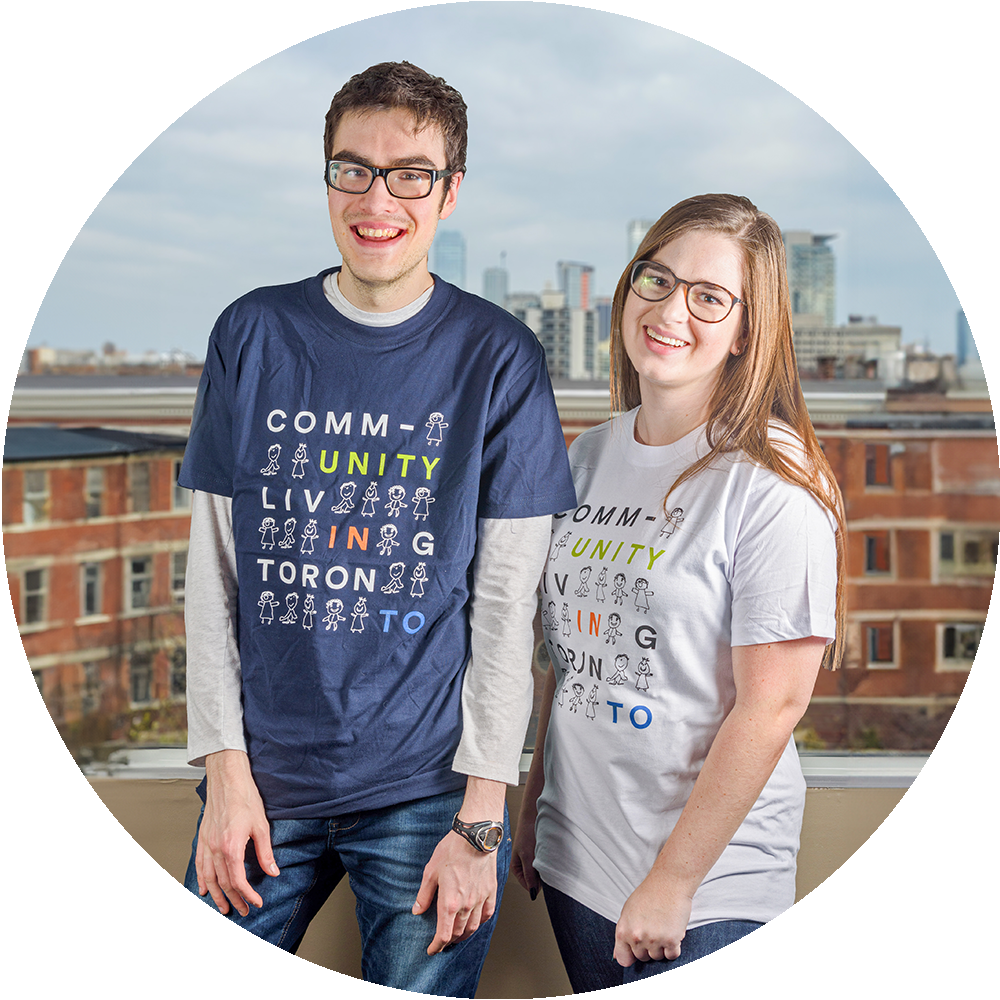 Two people smiling standing in front of a building